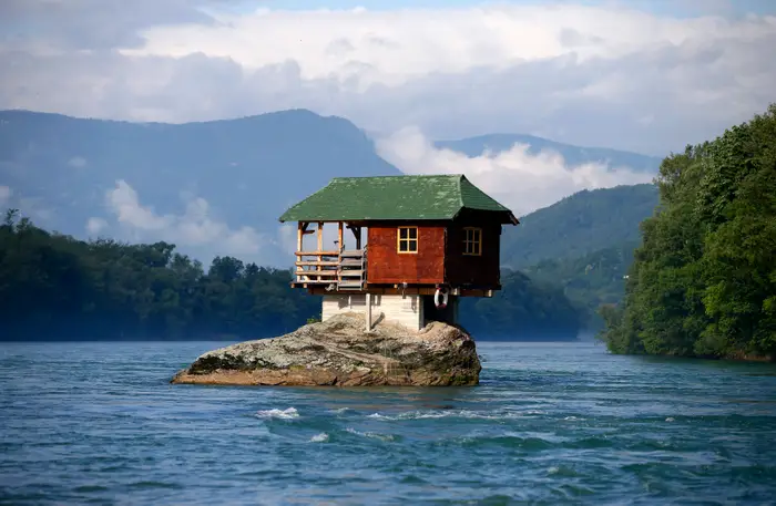 this-house-sits-on-a-rock-in-serbias-river-drina-a-group-of-young-men-decided-that-the-rock-was-the-ideal-place-to-build-a-shelter-in-1968-and-it-has-withstood-severe-storms-and-floods-for-over-50-years