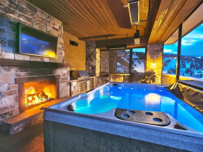 Another major selling point is the enclosed hot tub, with incredible views, a TV, and a fireplace