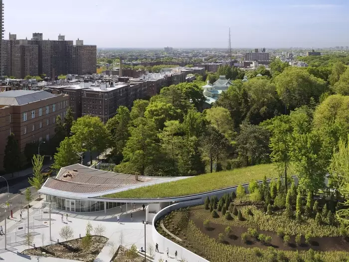 As plants from the garden extend down and over the roof  of the building, the design of the Visitor Center at the Brooklyn Botanic Garden