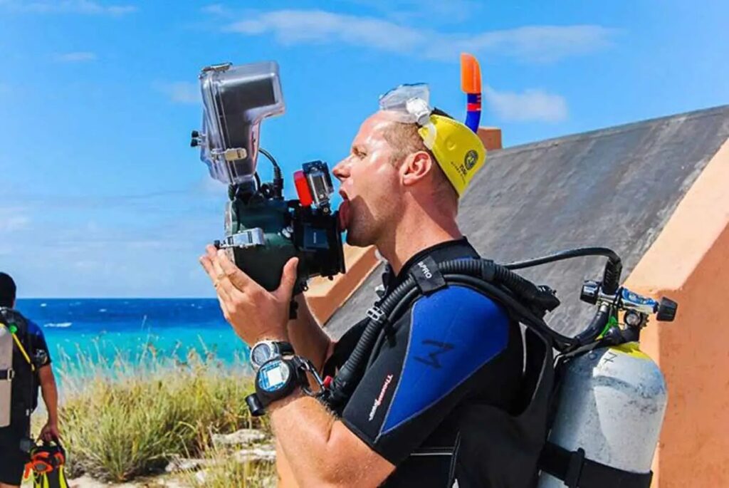 Anhede licks the lens of his underwater camera to  prevent water droplets from sticking to it