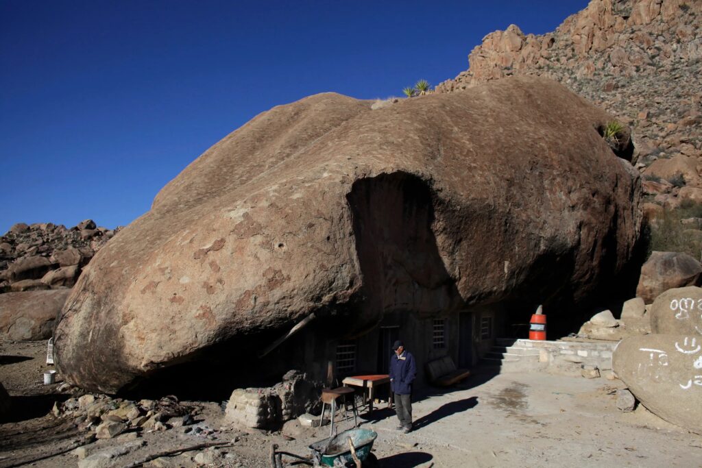 here-venito-hernandez-stands-outside-his-sun-dried-brick-home-the-house-is-in-mexicos-northern-state-of-coahuila-and-is-131-feet-in-diameter-with-a-huge-boulder-used-as-the-roof